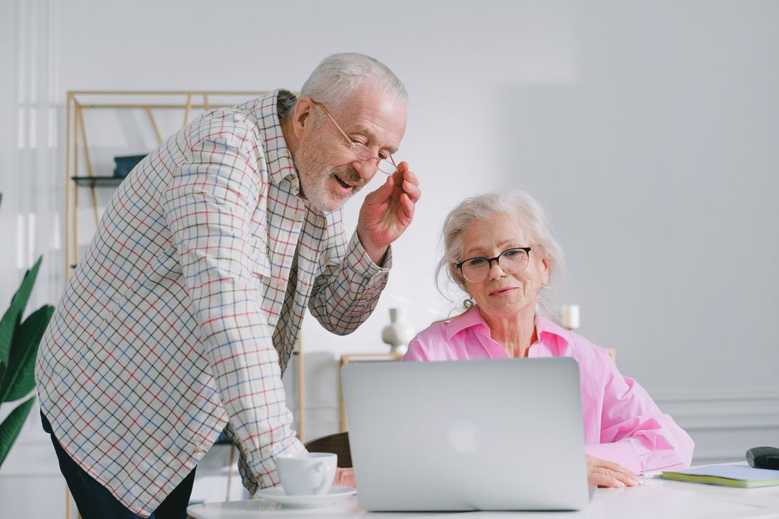 An older couple looking at a laptop together, calm and focused