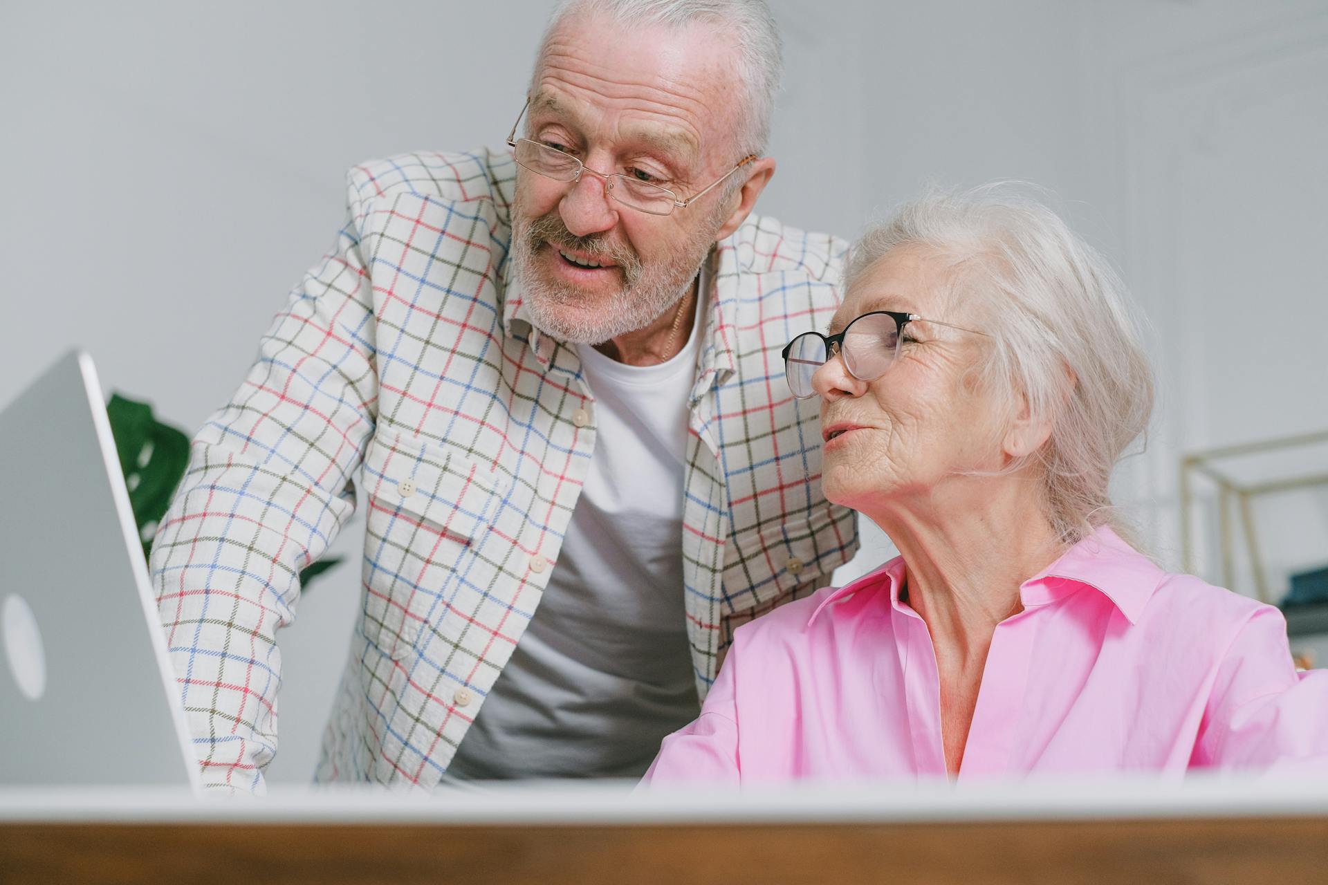 A senior couple enjoying time together while using a laptop, showcasing love and technology.