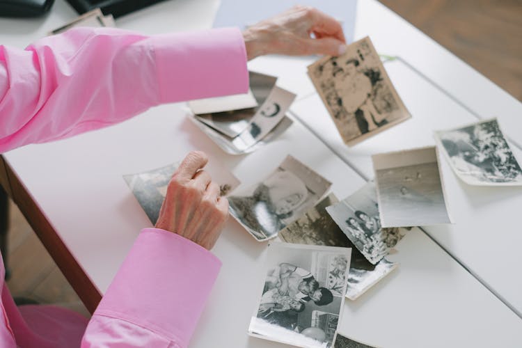 Close-up Of Woman Looking Through Old Pictures