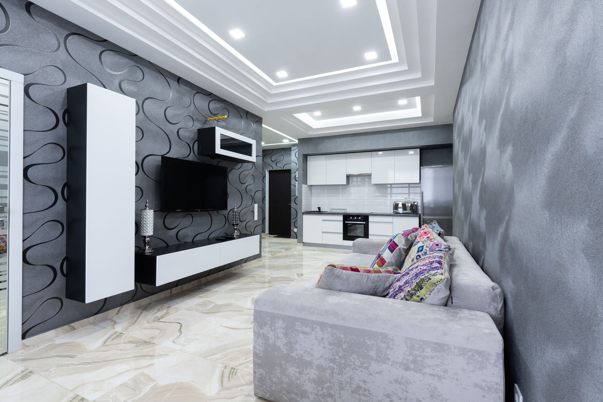 Interior of contemporary living room with comfortable sofa with colorful pillows and gray walls in luxury apartment