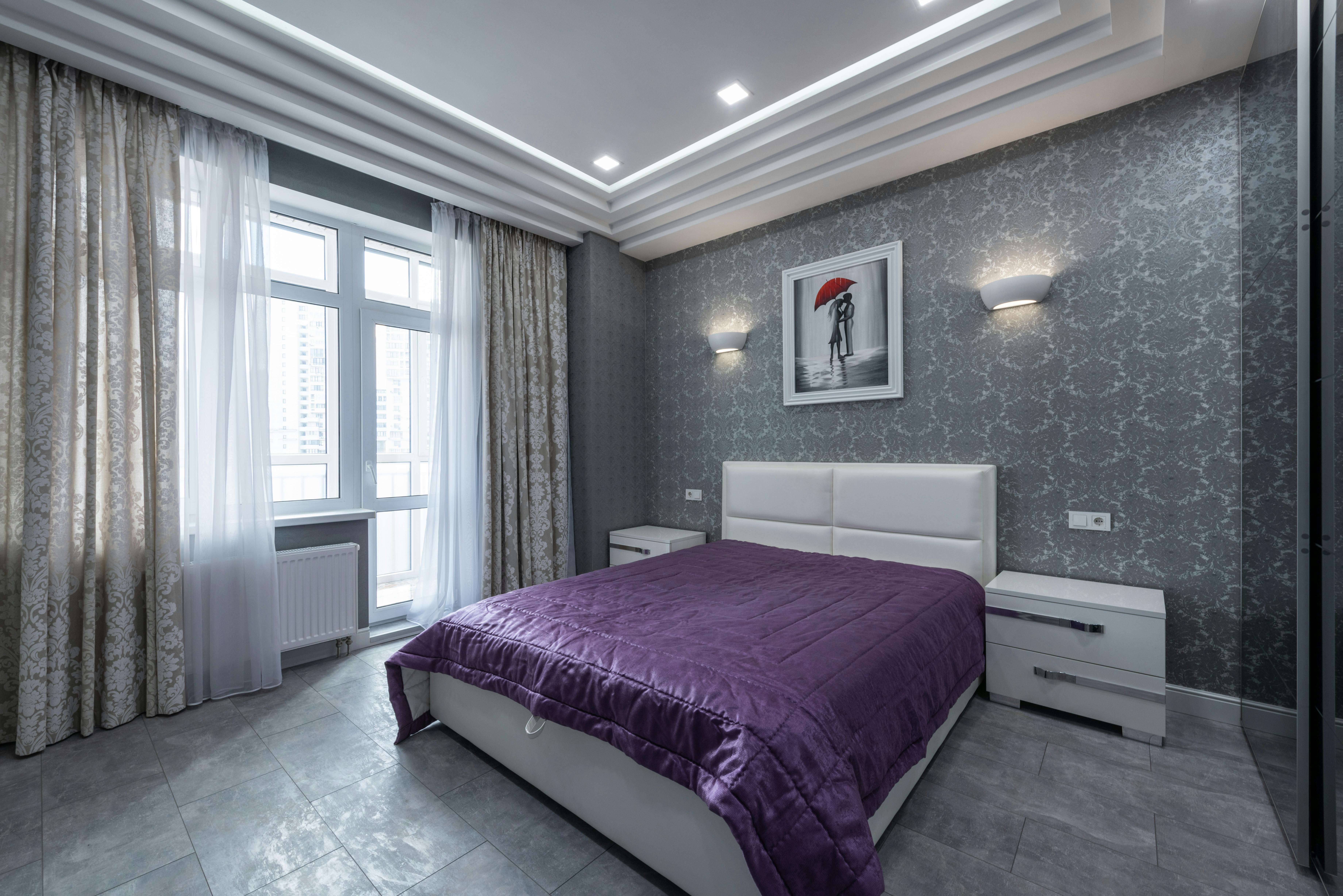 Nowoczesna sypialnia z grubymi zaslonami i szczelnymi oknami w stonowanej szarosci