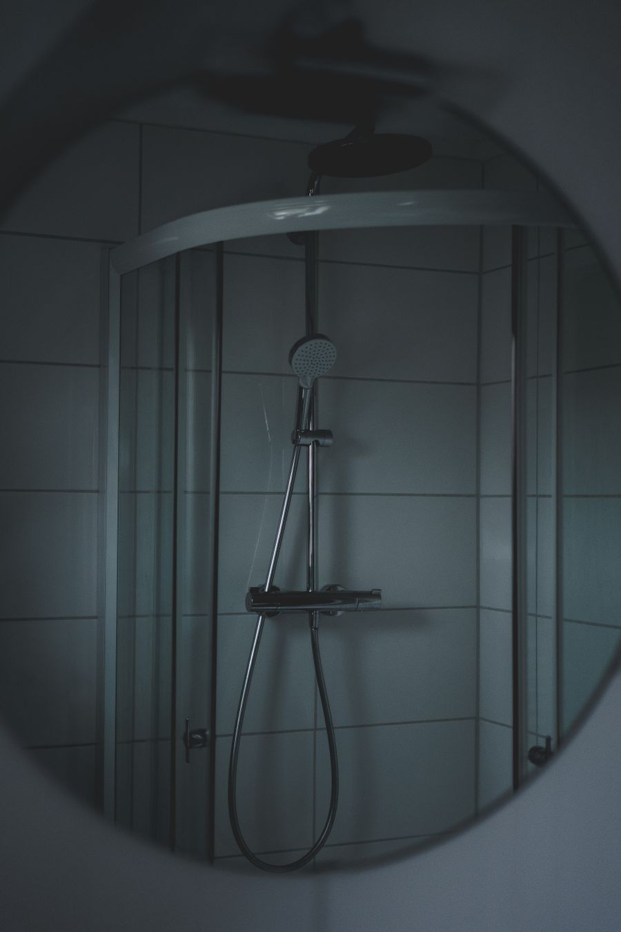 Moody modern shower reflected in a round mirror, photo by Jonas Thomann on Pexels