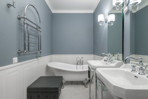 White bathtub placed in modern bathroom with clean sinks and mirrors in luxury apartment