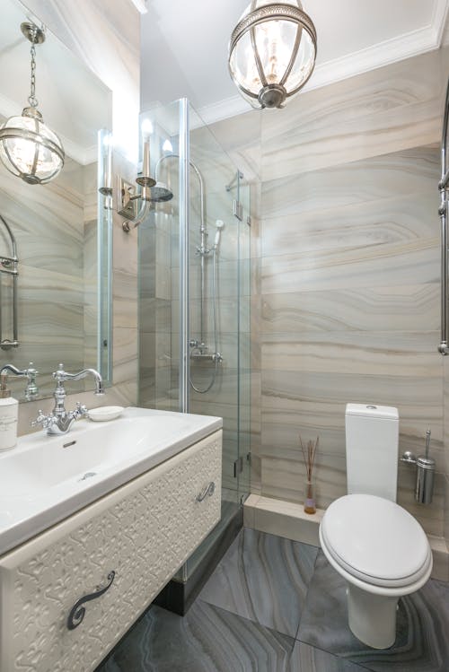 Contemporary bathroom with shower cabin near washbasin and toilet bowl