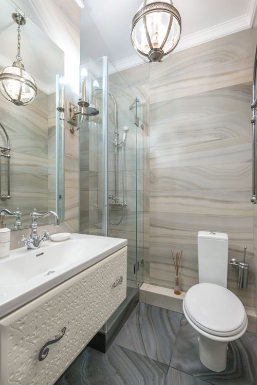 Free Interior of narrow modern bathroom with white basin and mirror next to shower cabin and toilet in modern apartment Stock Photo