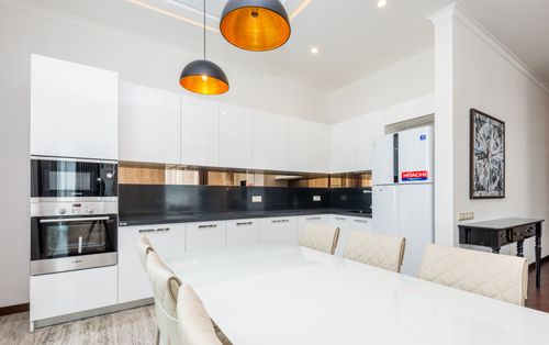 Free Elegant modern kitchen with white cabinets and sleek appliances featuring pendant lighting. Stock Photo