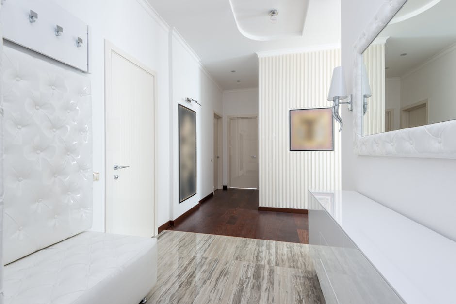 Bright modern corridor with white walls, doors, and elegant decor showcasing minimalist interior design.