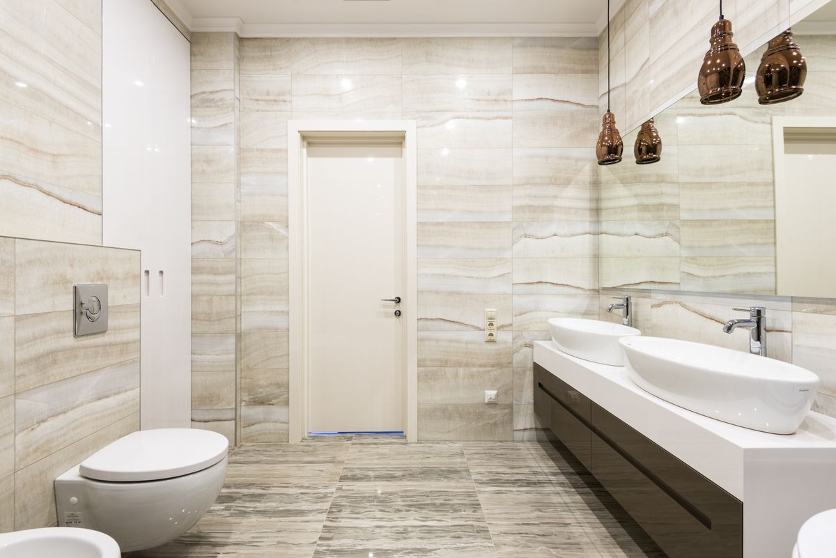 Bathroom with beige tiles and dual sinks