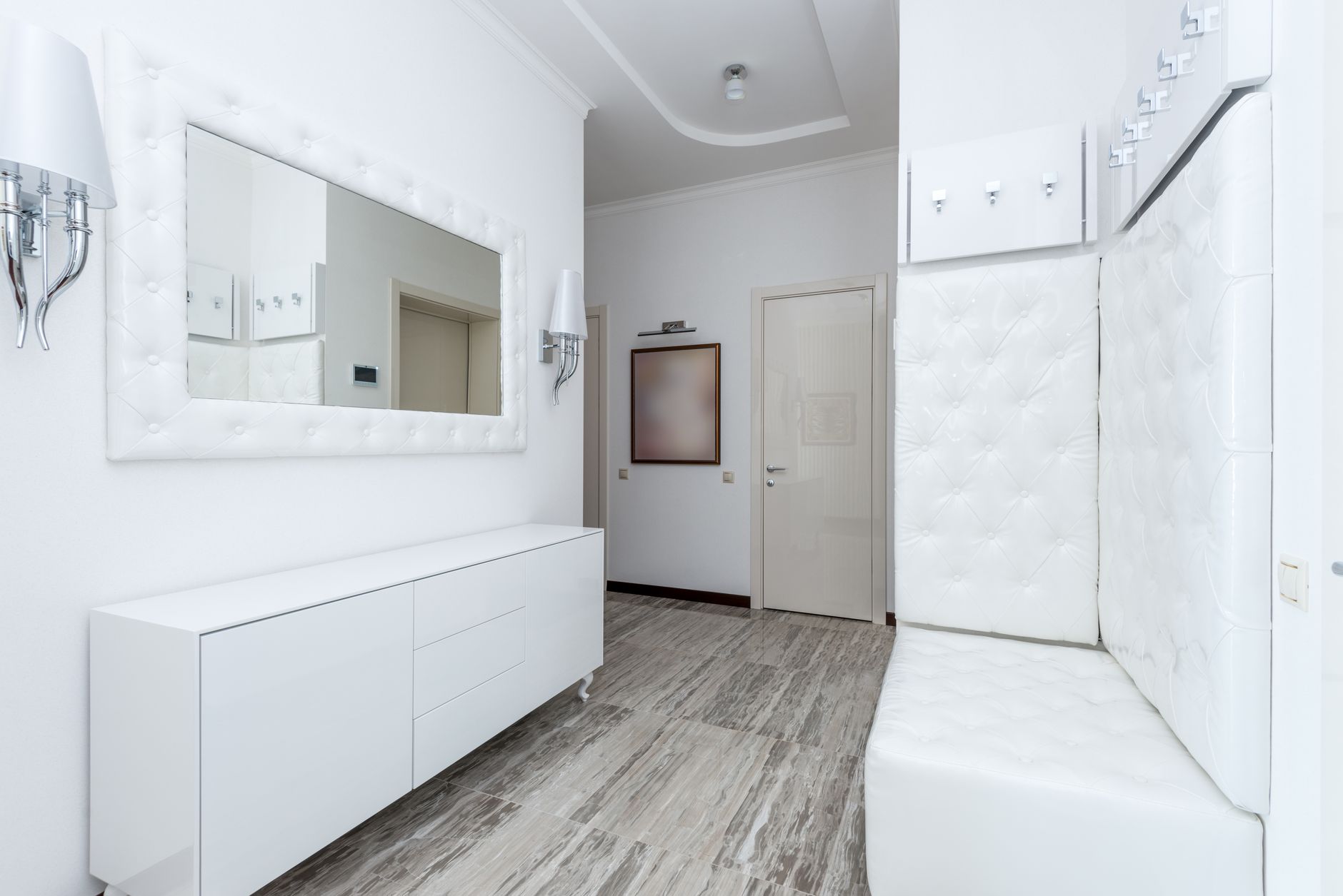 Contemporary hallway emphasizing modern cabinetry with neutral colors and seamless surfaces.