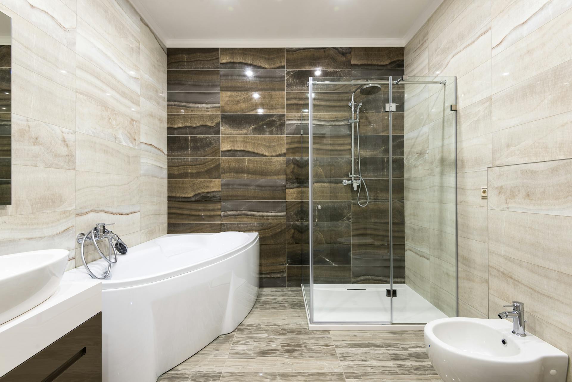 Spacious modern bathroom featuring a glass shower and marble tiles for a luxurious feel.