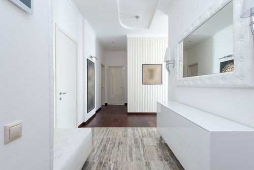 Free Bright corridor with contemporary design featuring white walls, minimal decor, and mirror. Stock Photo