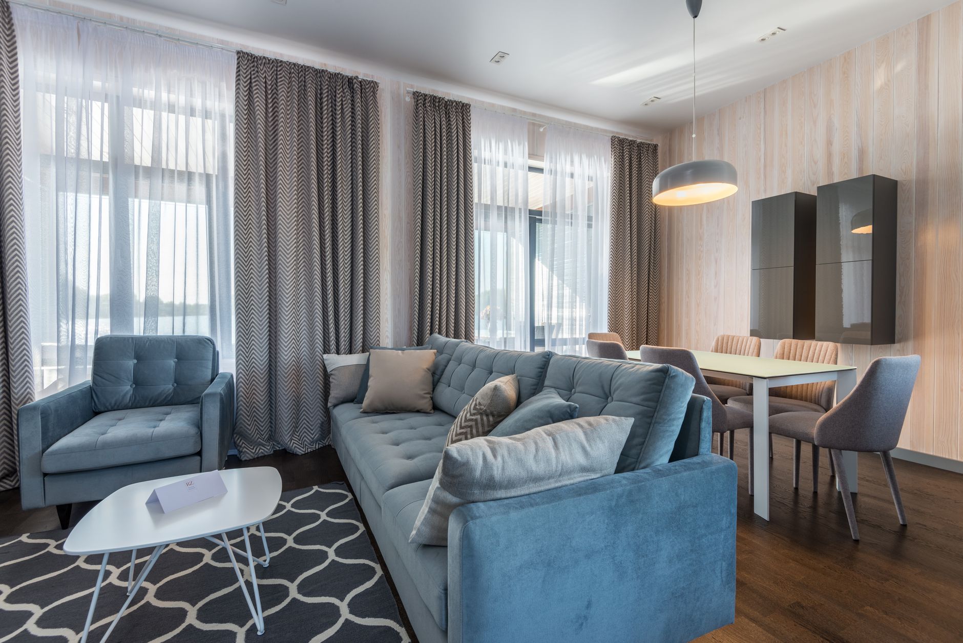 Sıcak ışıklandırma ve kitaplarla kişiselleştirilmiş rahat bir kiralık oturma odası
