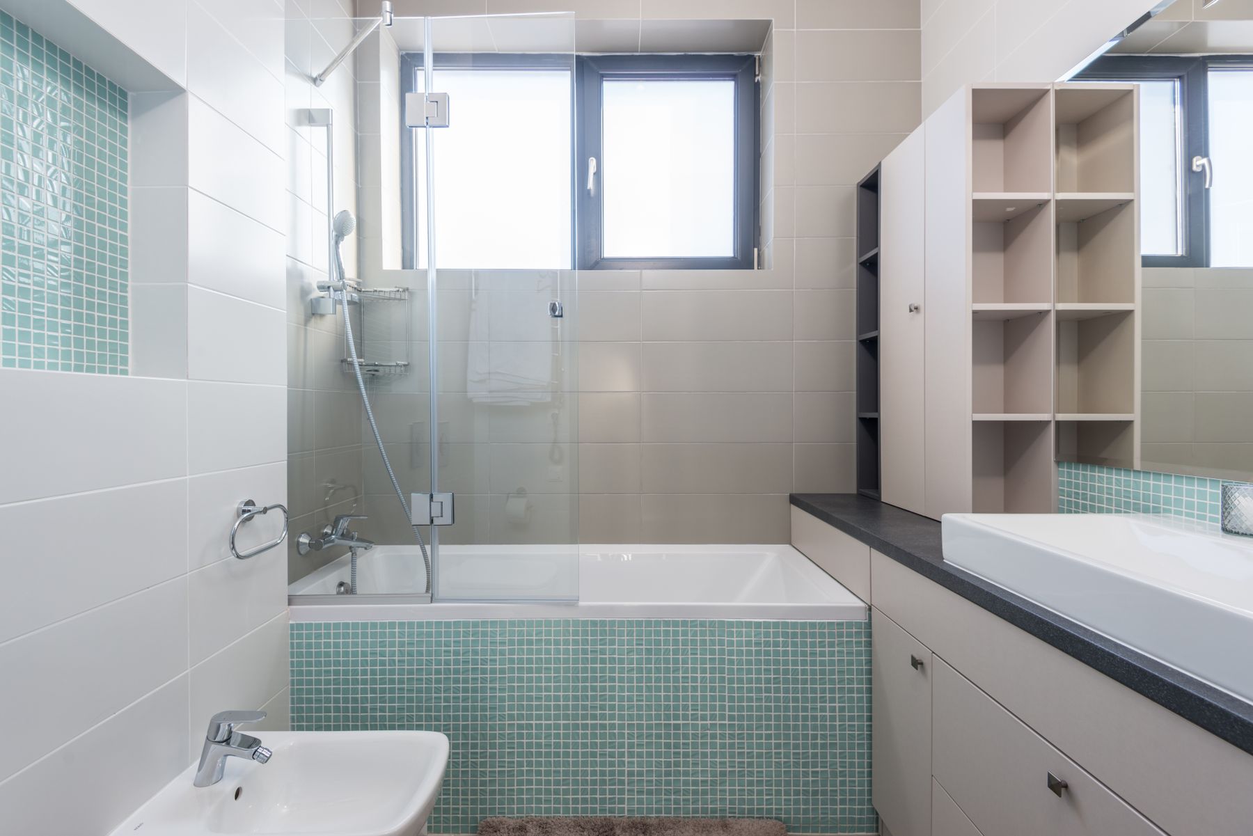 Modern bathroom with a bathtub, shower and restrained metal fittings