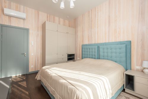 Free Spacious bedroom with teal accents and modern furnishings for a cozy atmosphere. Stock Photo