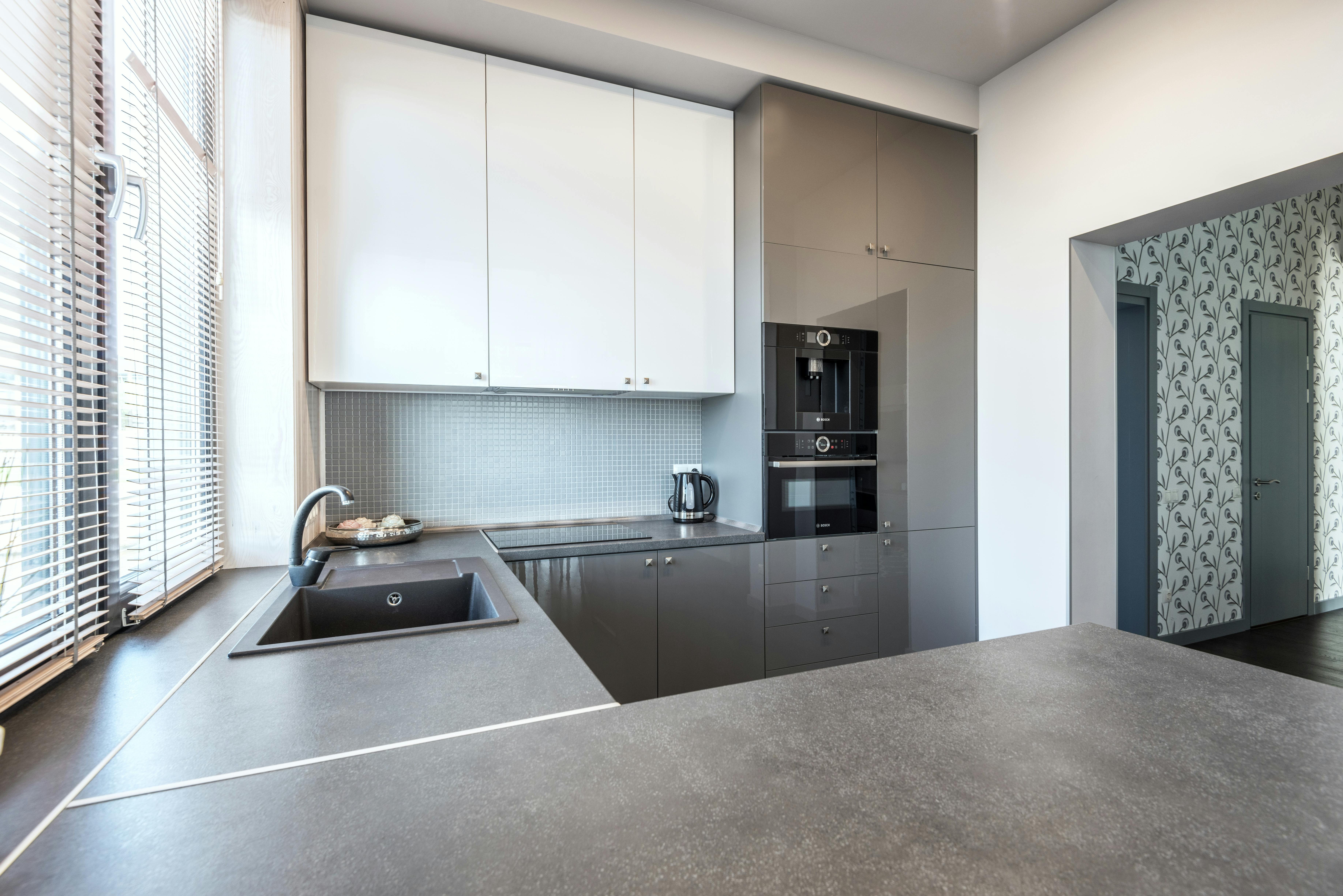 stainless steel sink beside white wall