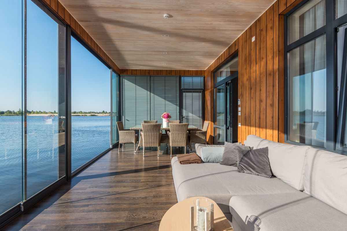 Modern renovated lake home interior with massive floor-to-ceiling windows