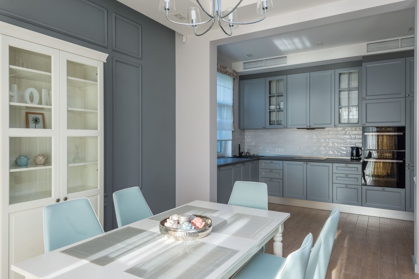 Grey-blue fitted kitchen opening onto a dining area