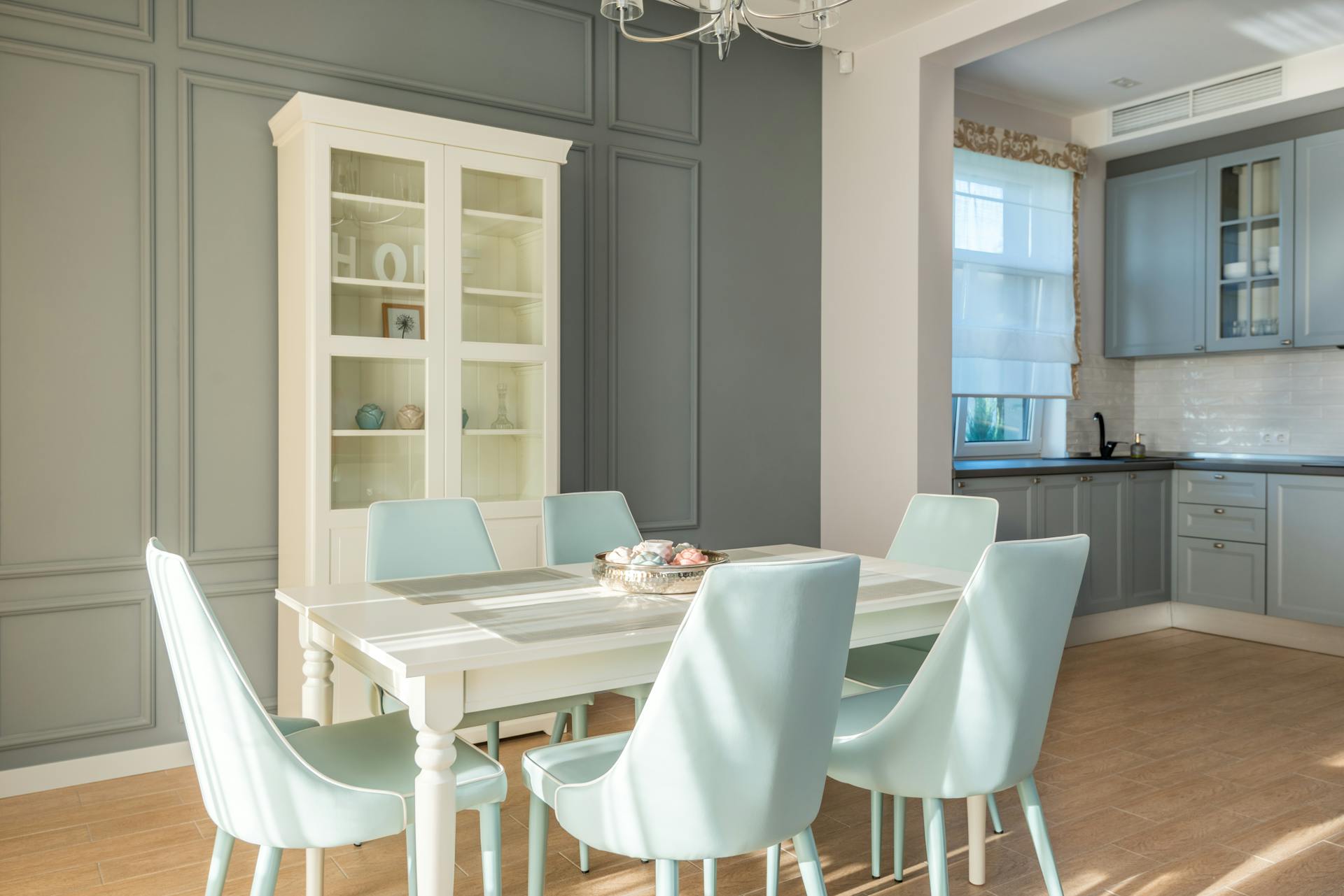 Elegant dining area featuring light blue chairs and a chic cabinet for a tranquil home interior.