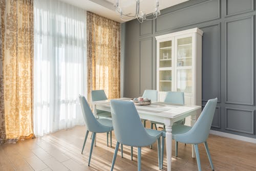 A Dining Table with Chairs Near the White Cabinet