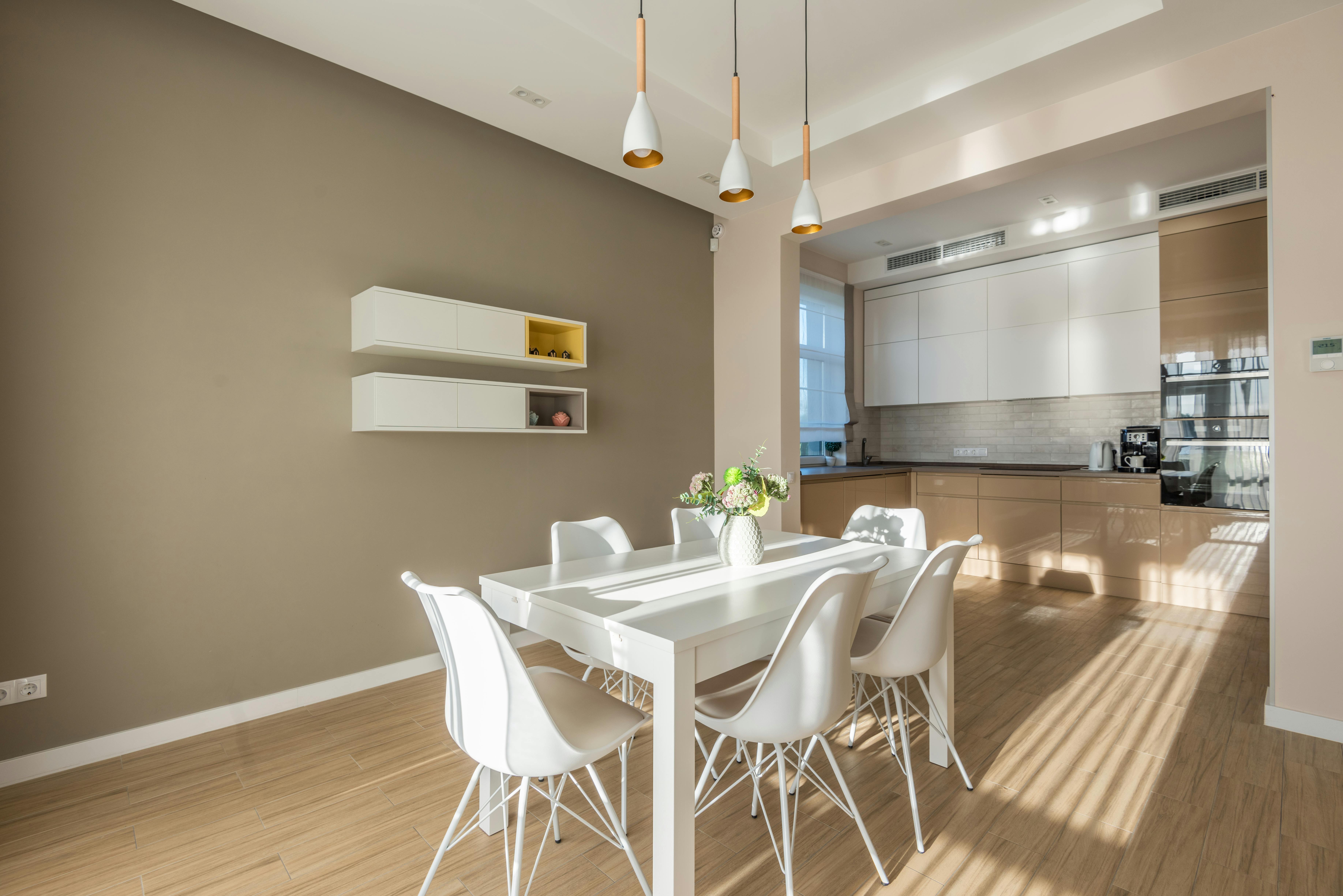 Bright and elegant modern kitchen with dining area, highlighting minimalist design.