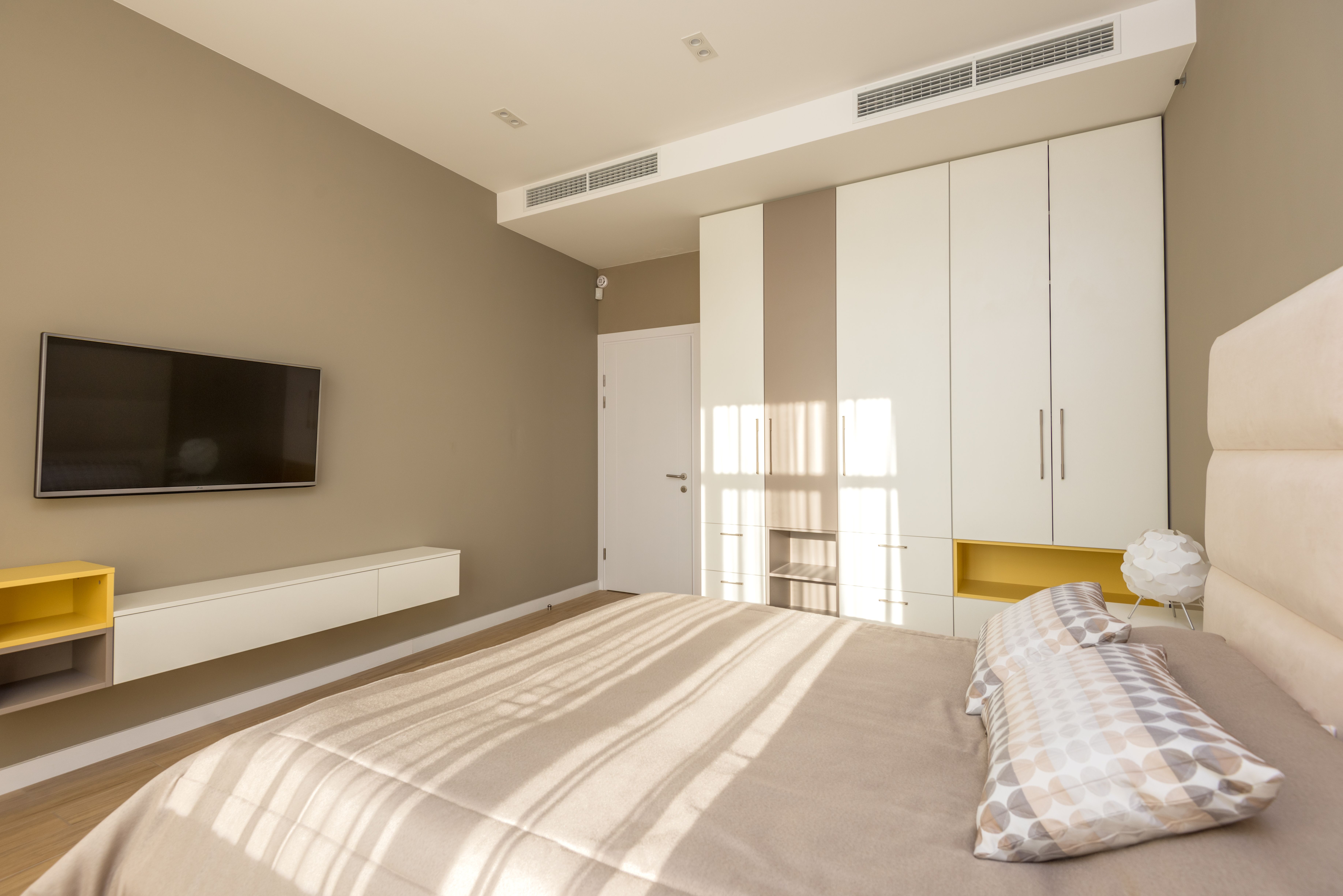 Neutral bedroom with soft sunlight, clean walls, and minimal design
