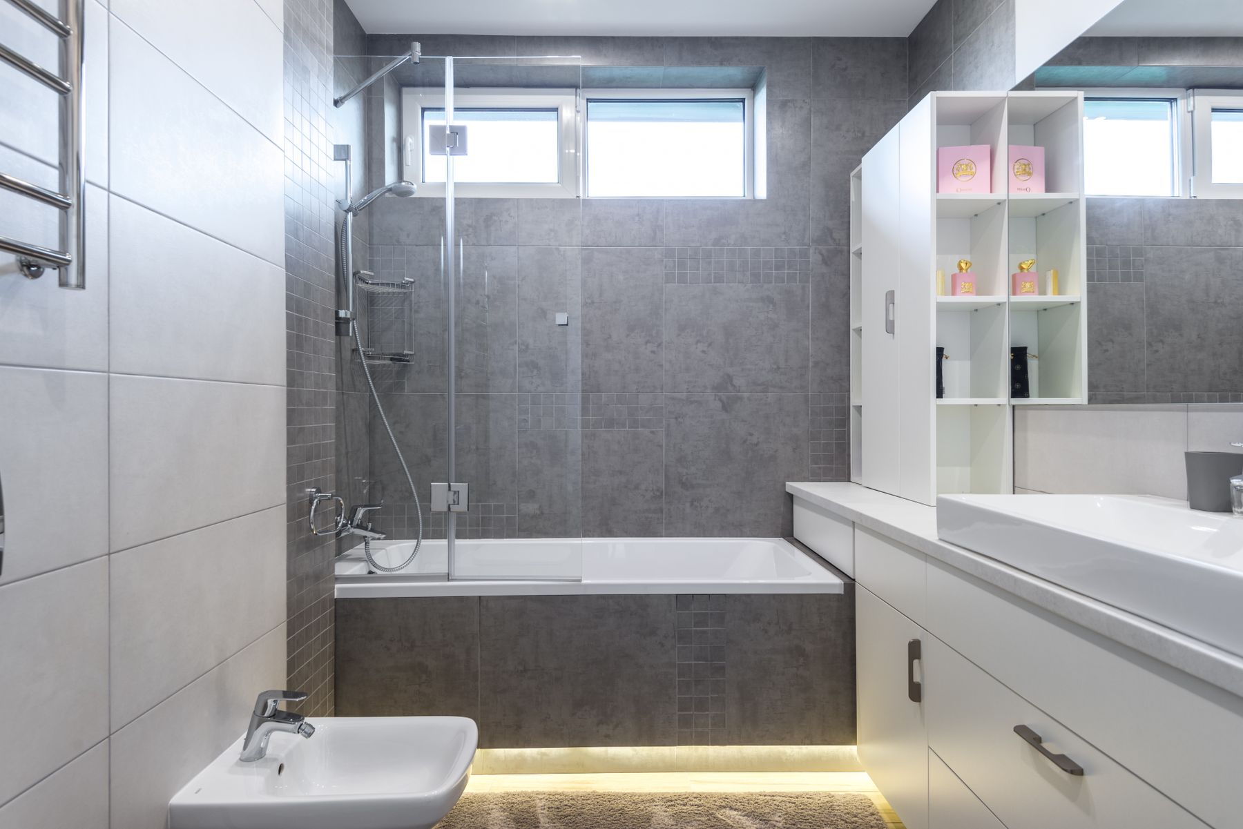 Contemporary grey bathroom with bath, shower, vanity and repeated material finishes