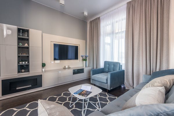 Monochrome portrait of a smiling young woman with eyes closed, exuding elegance.