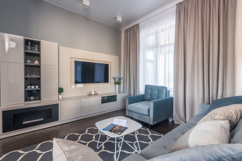 Monochrome portrait of a smiling young woman with eyes closed, exuding elegance.