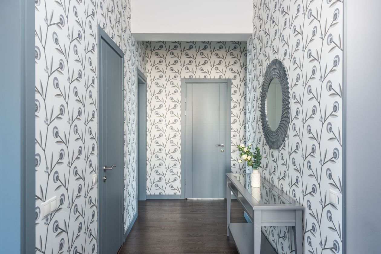 how to style an entryway table: a hallway with floral wallpaper, a console table, and a mirror