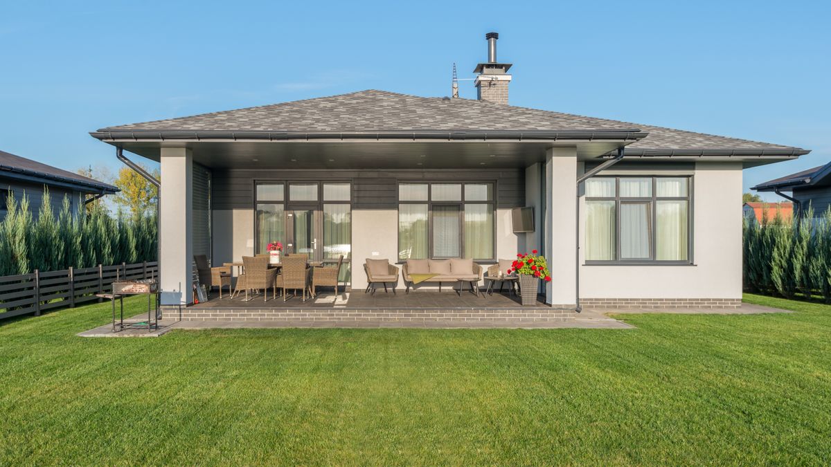A finished lawn behind a modern house — new sod needs deep watering for the first two weeks.