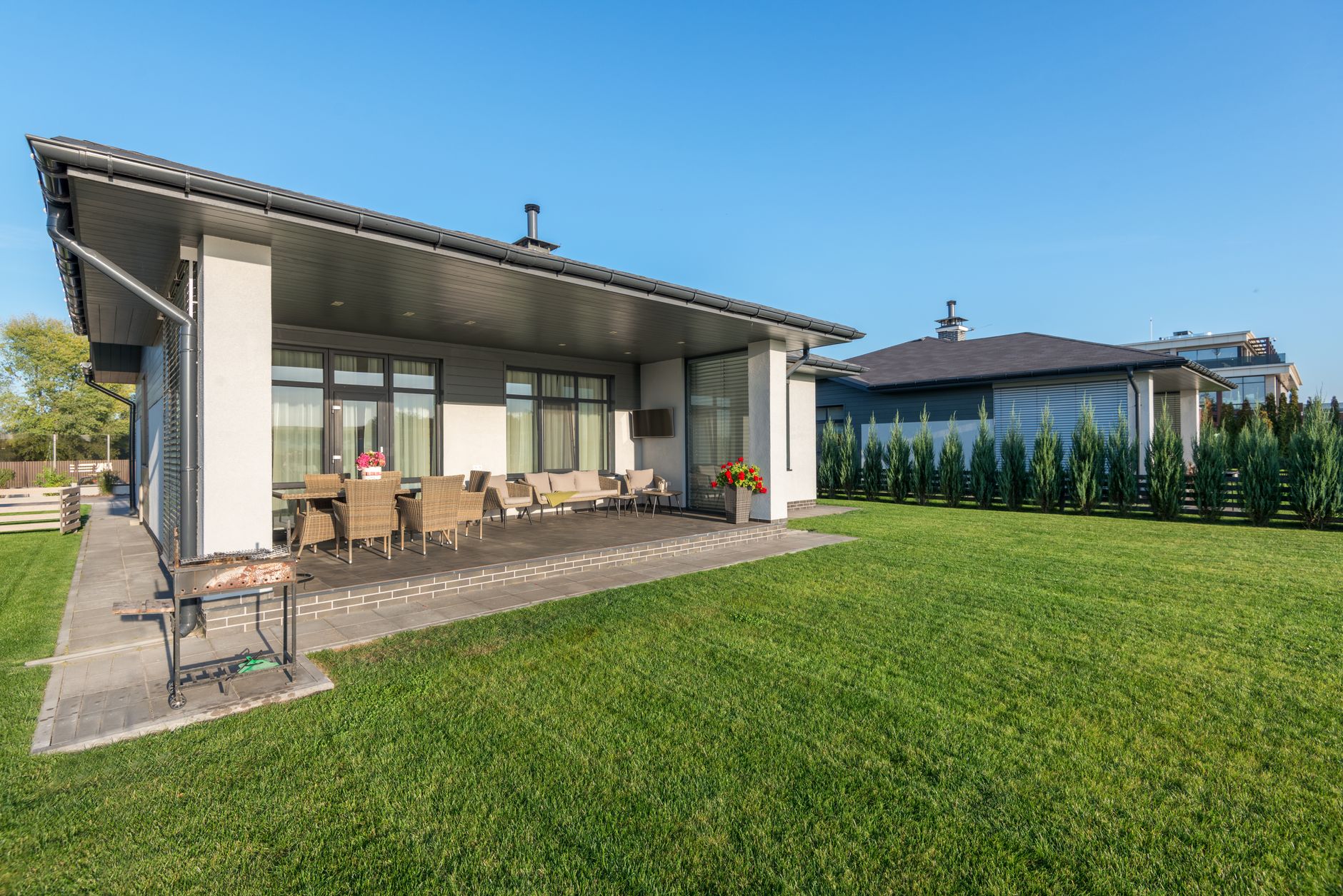 Modern Kitchener home with a finished concrete walkway and patio in a landscaped backyard. Modern Kitchener home with a finished concrete walkway and patio in a landscaped backyard.