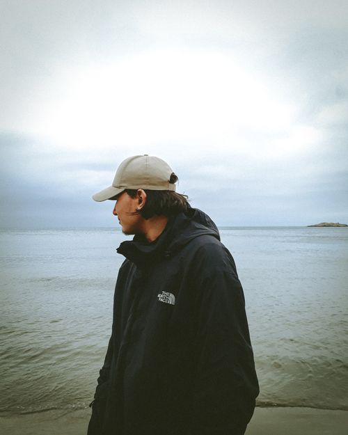Free Man in a black jacket and cap looking at the cloudy ocean in Staoueli, Algeria. Stock Photo