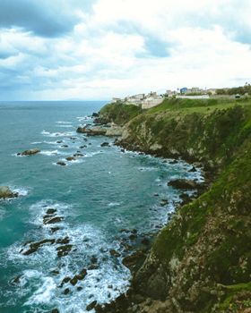 Dramatic landscape of El Marsa's rocky coast and cliffs under a cloudy sky.