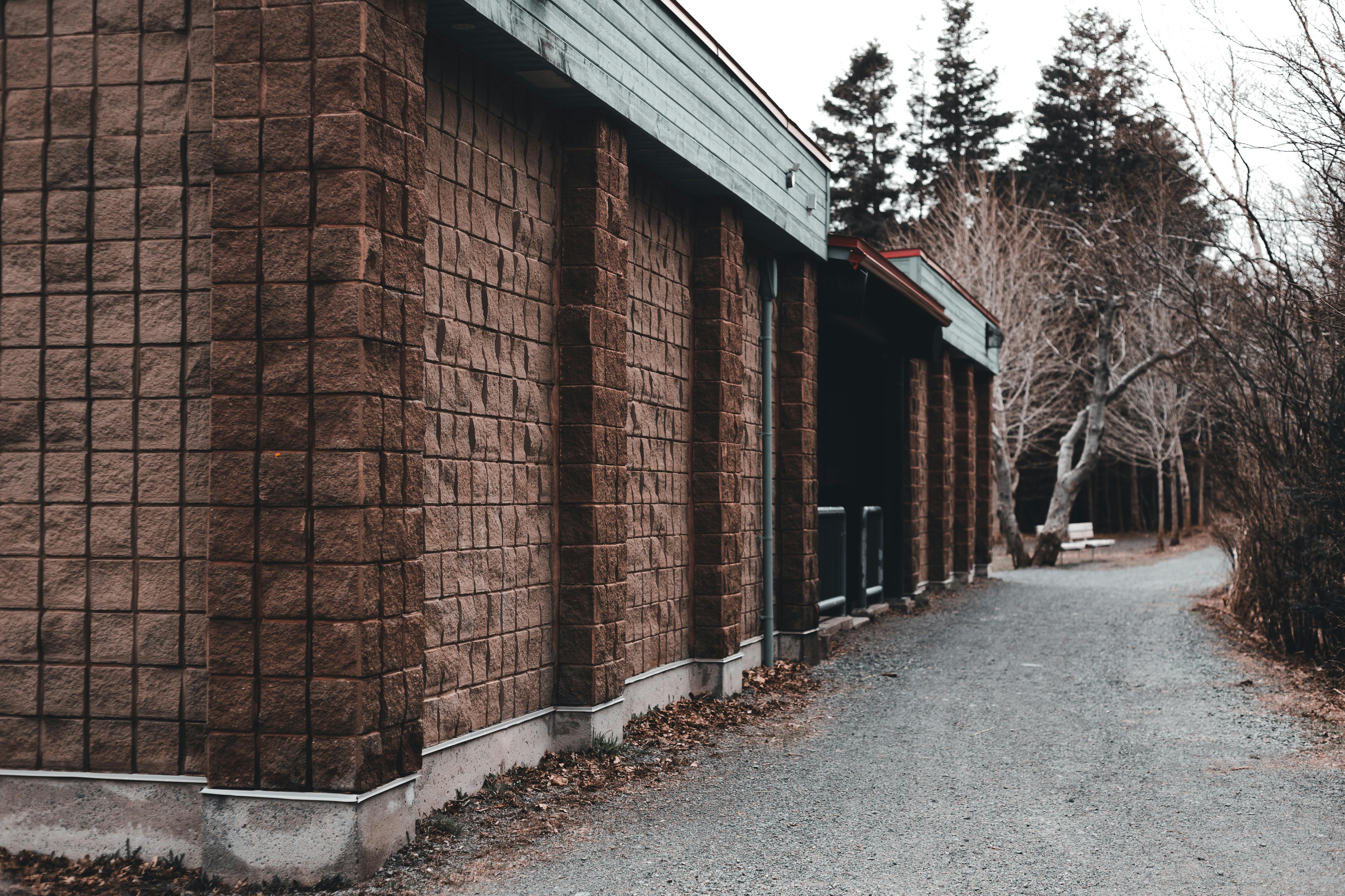 Free Brick building facade near leafless trees in countryside Stock Photo