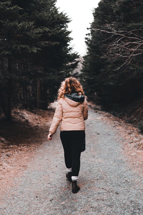 Free Faceless woman strolling on path near trees Stock Photo
