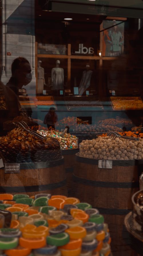 Free A colorful array of sweets displayed in a bustling street market, reflecting the vibrant city life. Stock Photo