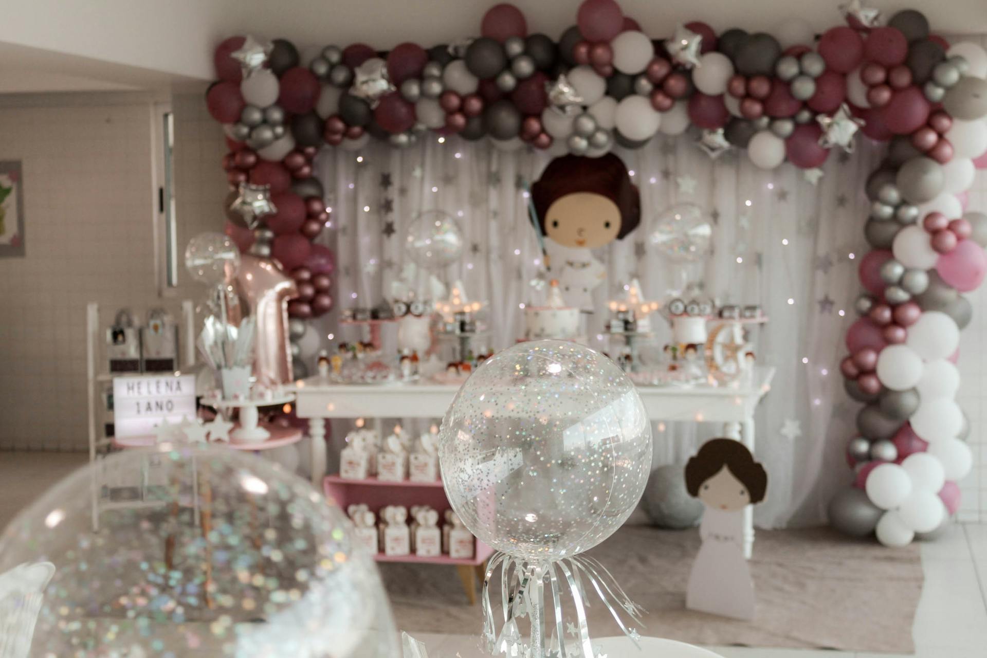 A magical indoor birthday party setup with balloons and fairy lights