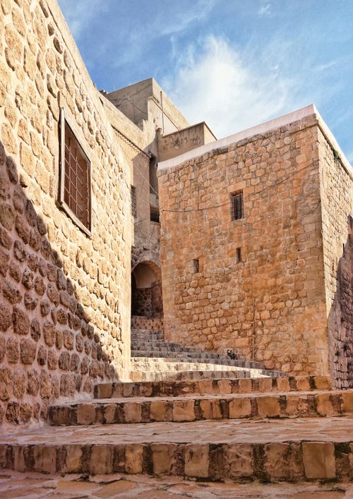 Free Explore the ancient stone facades and steps of Mardin's old town under a clear sky. Stock Photo