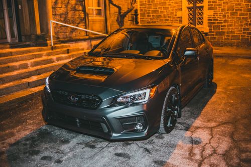 Free A sleek gray Subaru WRX automobile parked in an urban setting at night. Stock Photo
