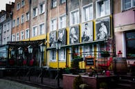 在这座古色古香的欧洲小镇上，街景色彩缤纷，配有经典电影海报和户外座椅