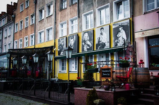 在这座古色古香的欧洲小镇上，街景色彩缤纷，配有经典电影海报和户外座椅