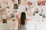 Person looking at a wall of pinned images and cards