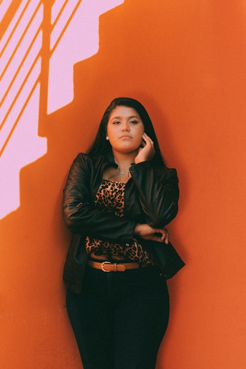 A Woman Standing Beside Orange Wall