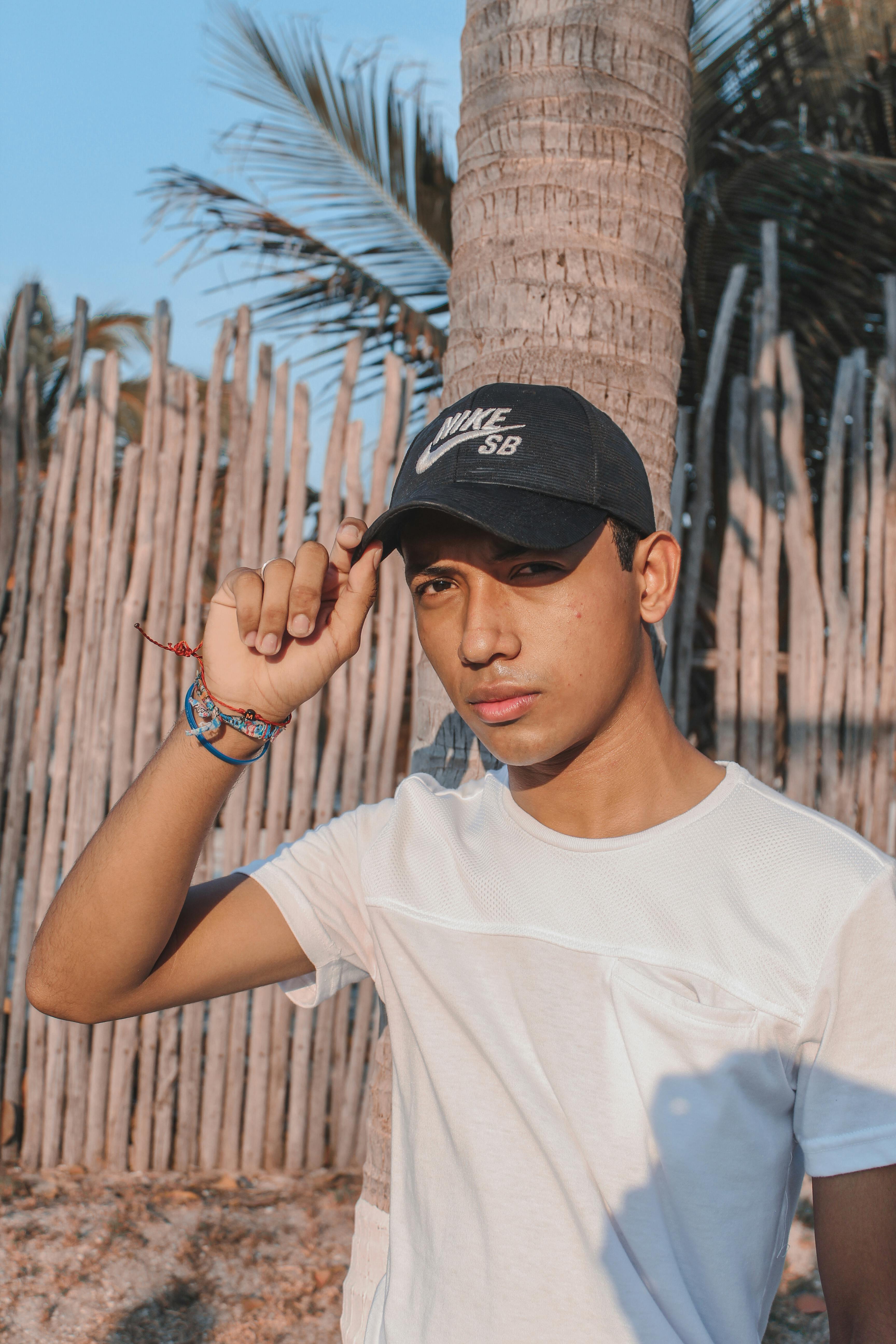 a man in white shirt holding his black nike cap