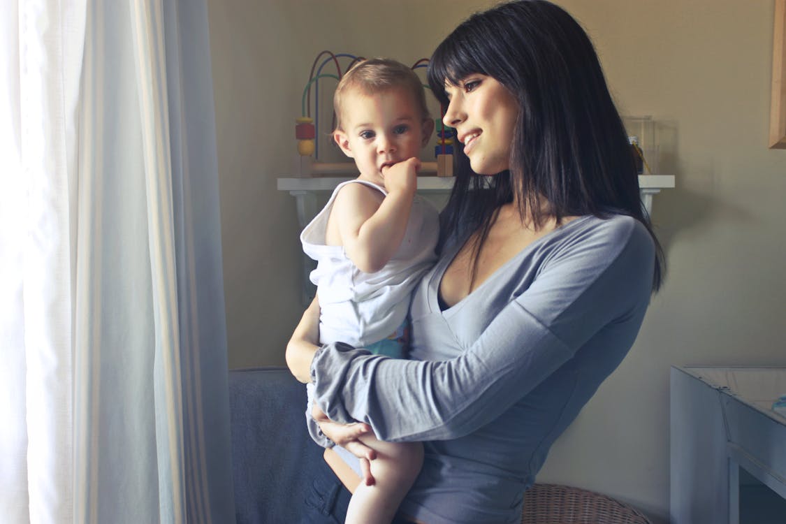 Free Mother Carrying Her Baby Boy Stock Photo