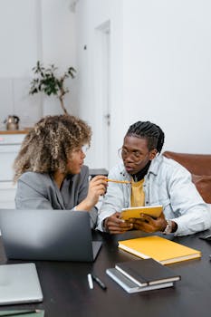 Two colleagues engaged in a teamwork session, using laptops and tablets.