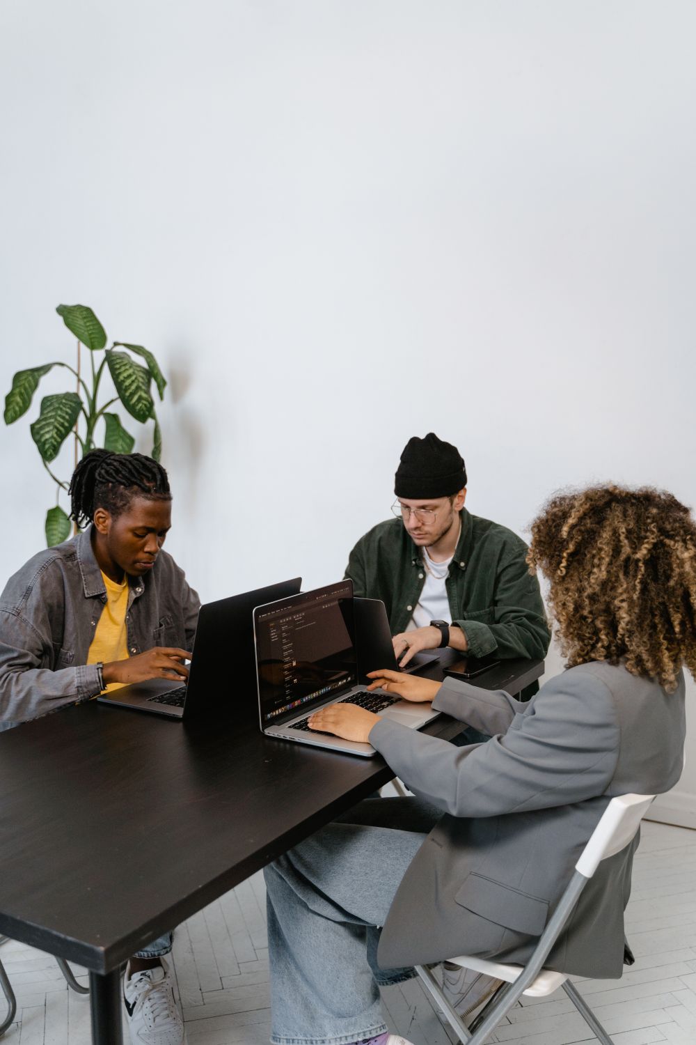 Diverse professionals collaborating with laptops in an office