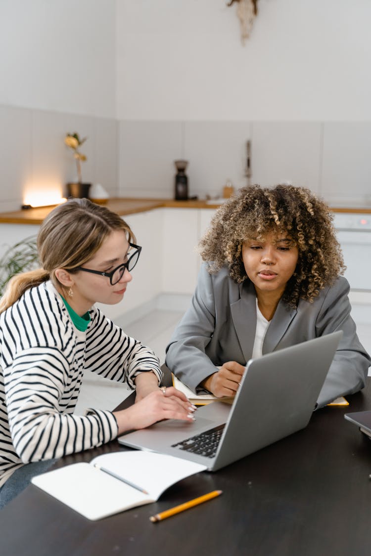 Two Women Brainstorming A Business Project At A Meeting