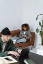 Man in Black Knit Cap and Gray Long Sleeve Shirt Sitting on Brown Sofa