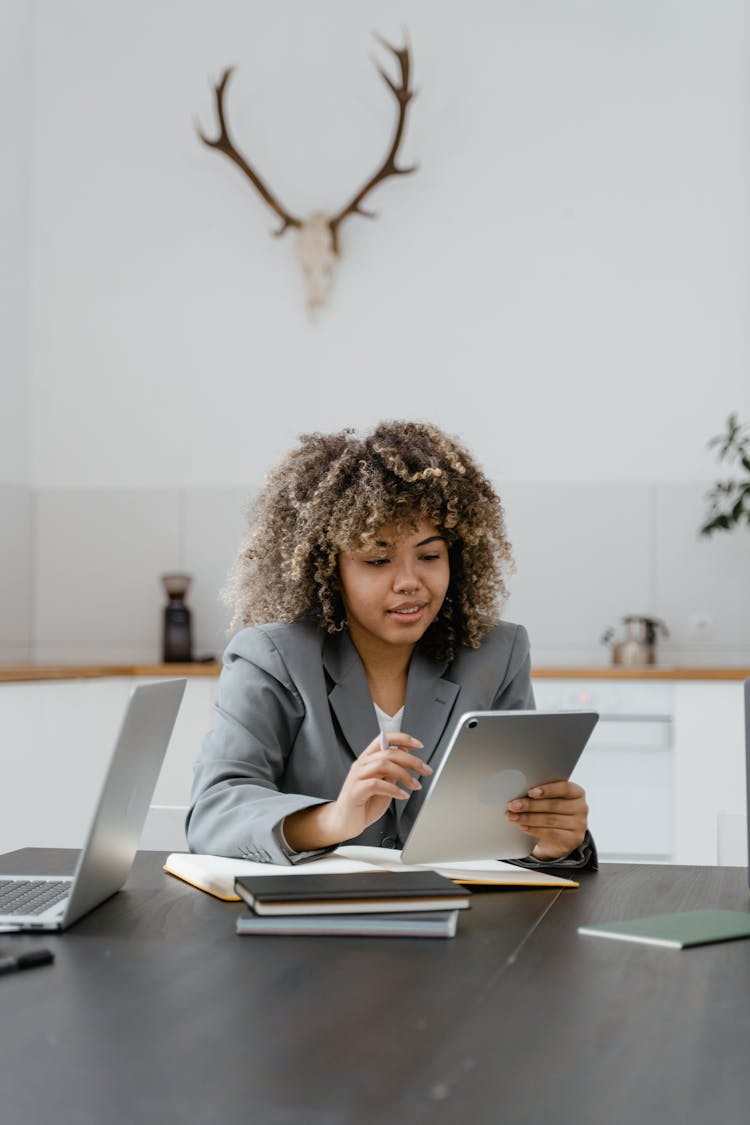 Woman Sitting On The Table Using An Ipad 